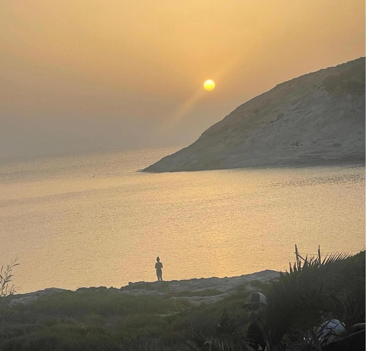 Tramonto sul mare, sole e figura in silhouette